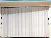Front view of a white, solid curtain sliding, folding security shutter.
