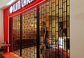 A black, open type sliding security shutter at the entrance of a restaurant in a shopping centre