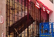 Blue scissor lift in front of a black sliding shutter