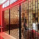 Black full height FlexiGlide Vision Guard sliding shutter to a restaurant entrance