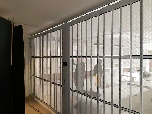 Light shining through the perforated panels of a flexiglide vision air sliding security shutter