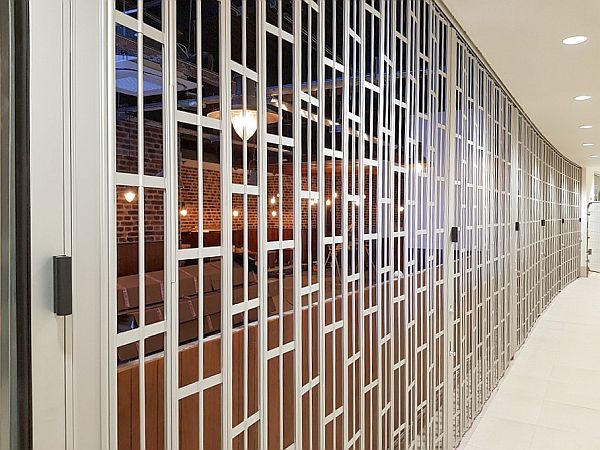 A robust - celing to floor - sliding folding security shutter with a light curve