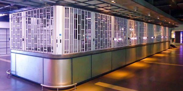 A lomg curved sliding shutter around a bar-island